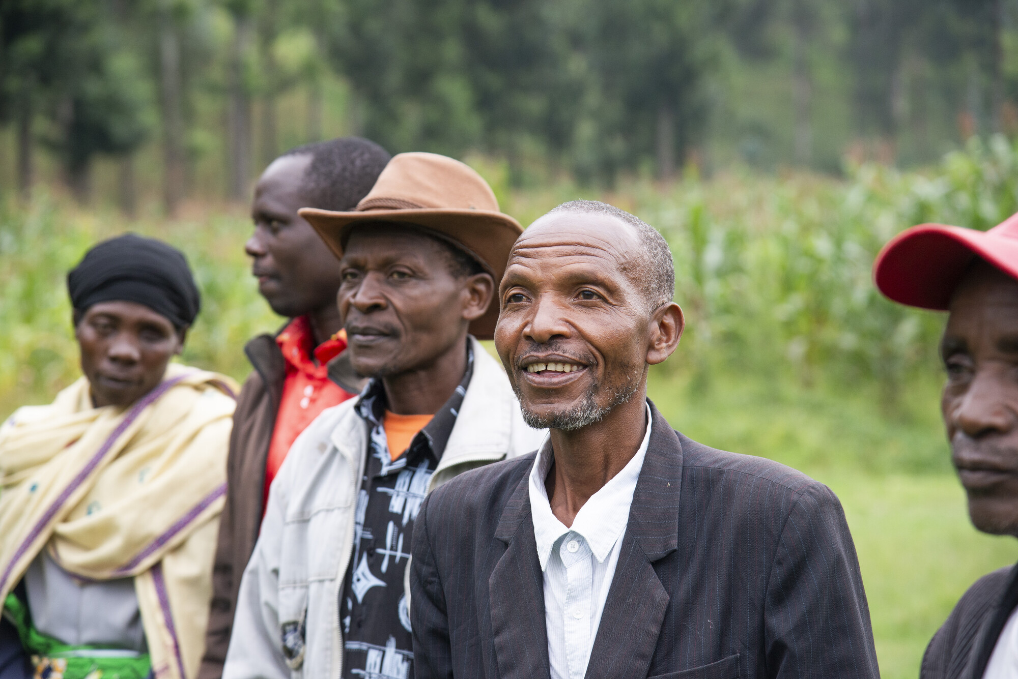 Members of a farmer field school in Rwanda’s Burera District greet staff from MCC, Peace and Durable Development (PDD) and Peace and Development Network (PDN) with song and dance.