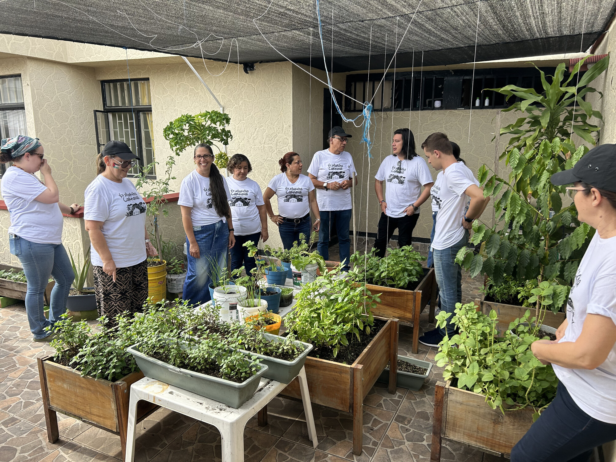 Puerto Rican church leaders and pastors tour the rooftop garden of a Mennonite church in Ibagué, Colombia with church members and pastors while on an MCC East Coast learning tour in May 2024.