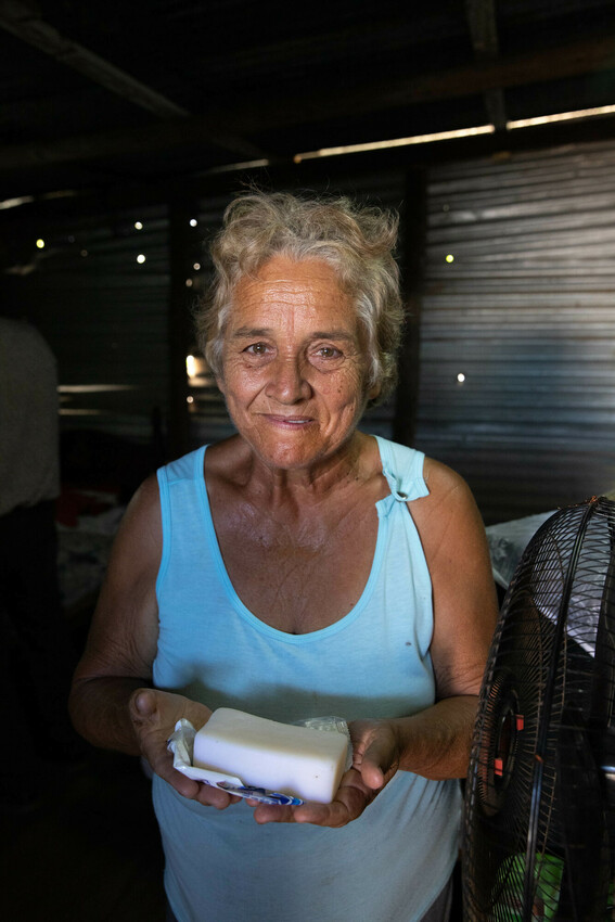 María Dolores Pérez Páez shows items received in an MCC relief kit. She has been using them sparingly, since she says doesn't know when she'll get soap or towels again.