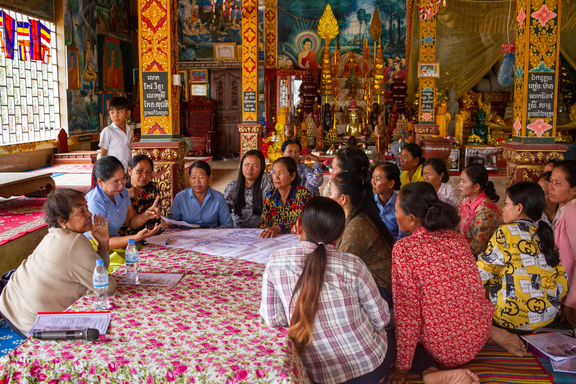 Participants at a district-level gender transformation forum held for members of the food and livelihood security program with MCC partner, Organization to Develop Our Villages (ODOV), create a poster