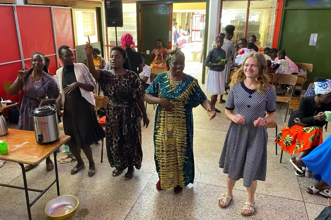 A group of five people dance in a line.