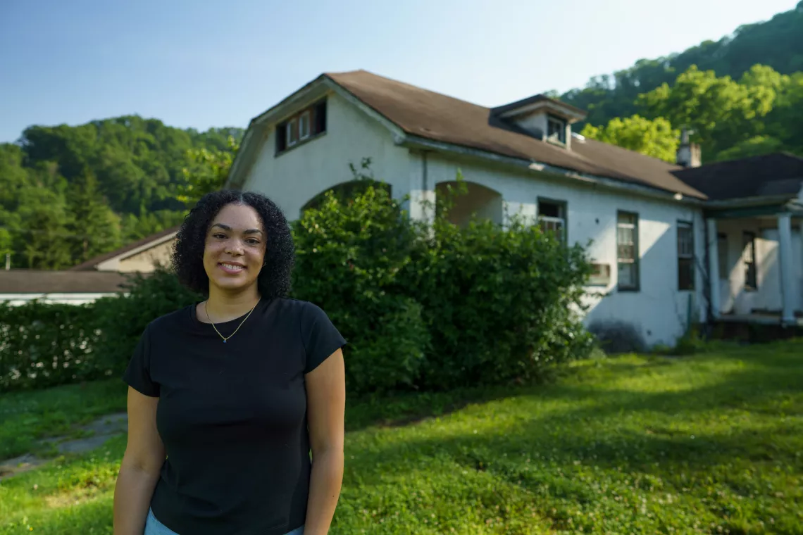 Lady standing in front of building on Dismukes property.