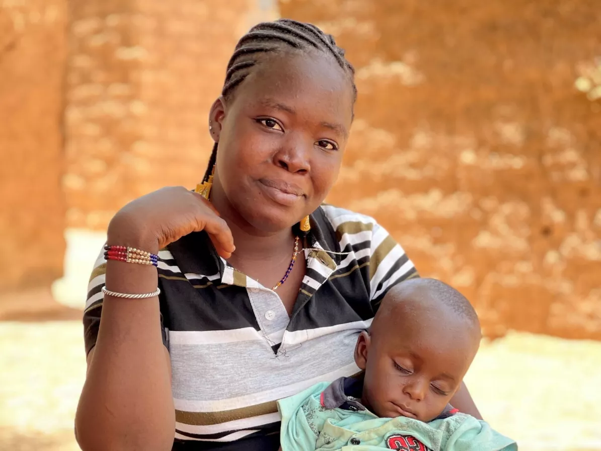 A mother sits and holds her sleeping child