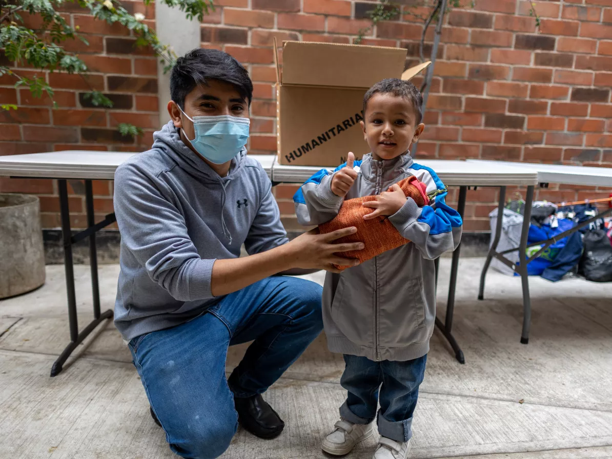 A man and young boy receiving relief kits