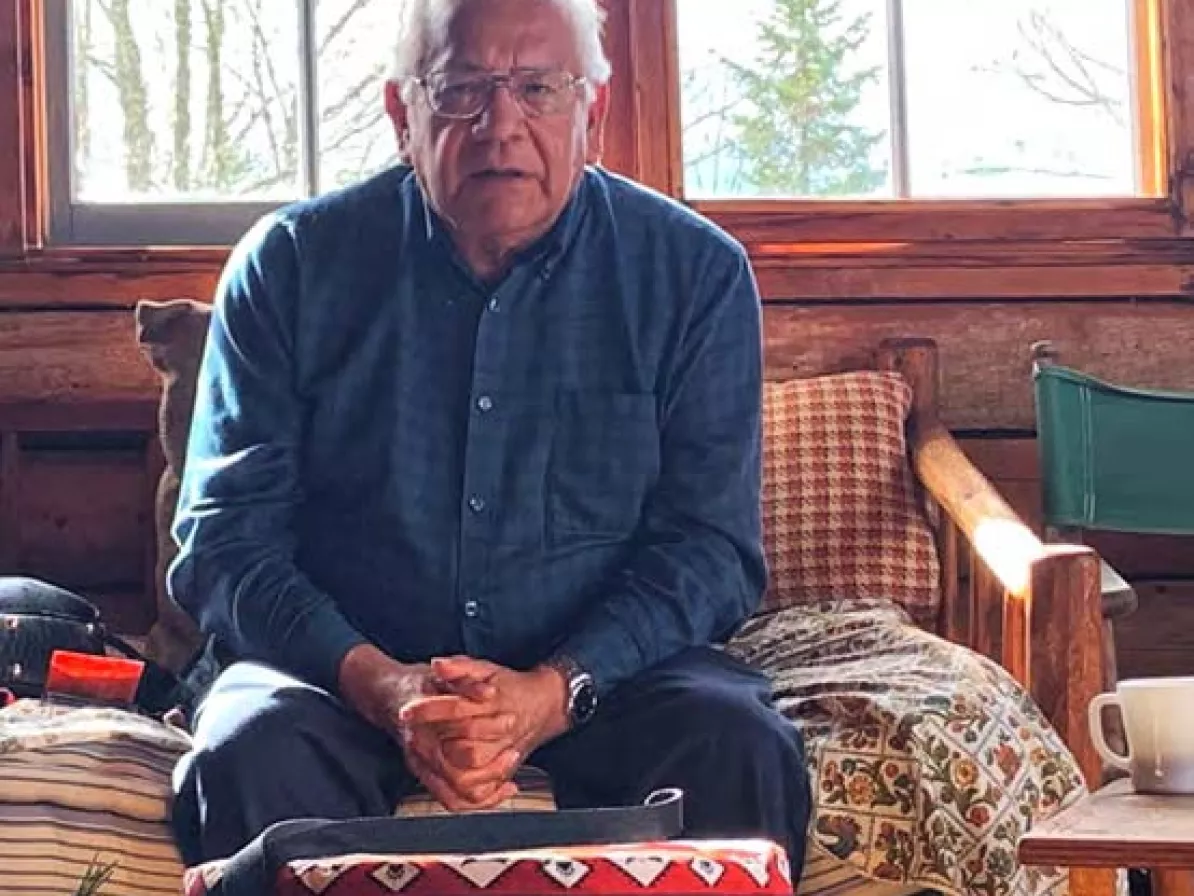 A man speaking while sitting on a couch