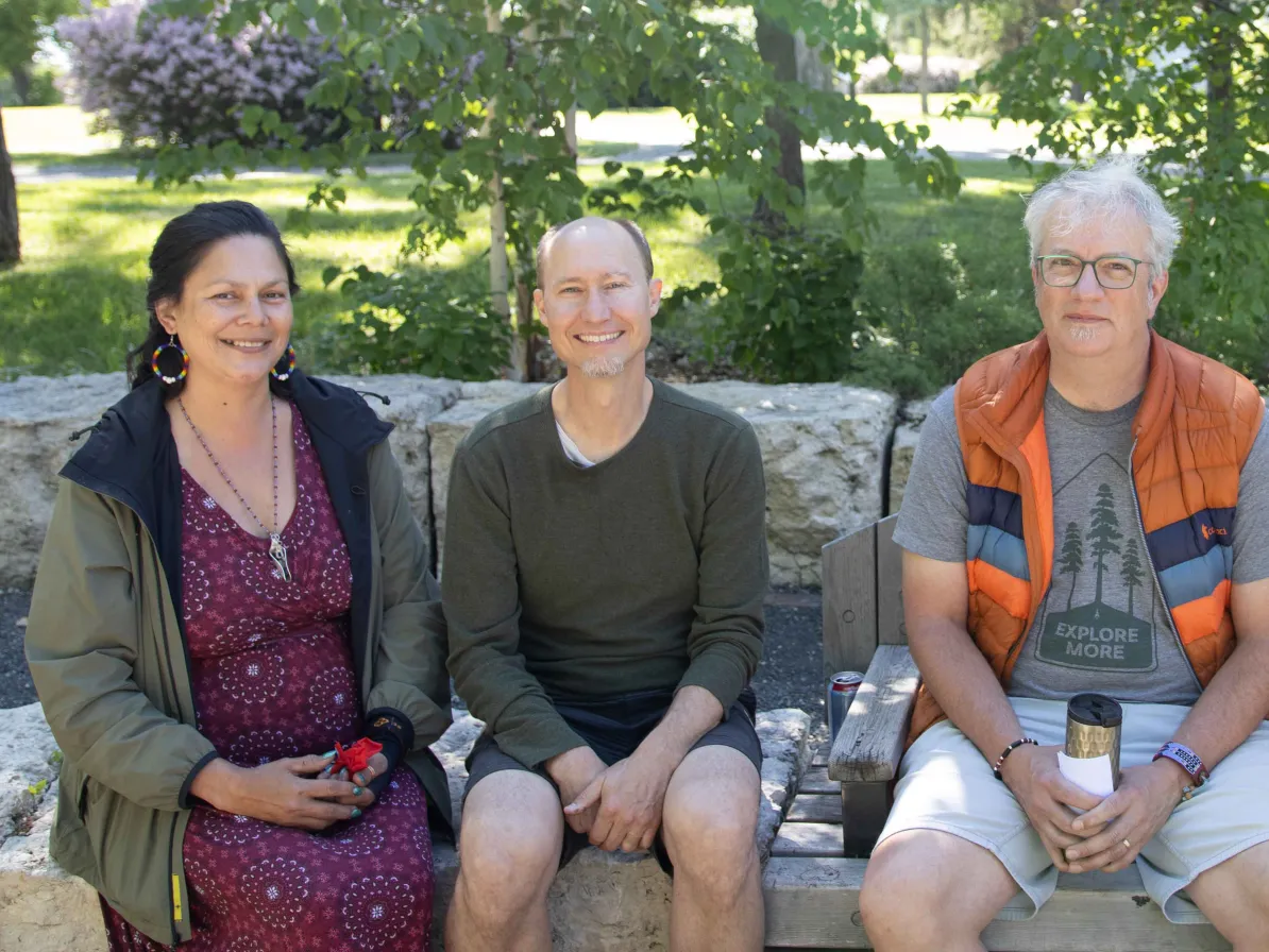 Ko’ona Saber, Kerry Saner-Harvey and Jonathan Neufeld sitting together on a bench