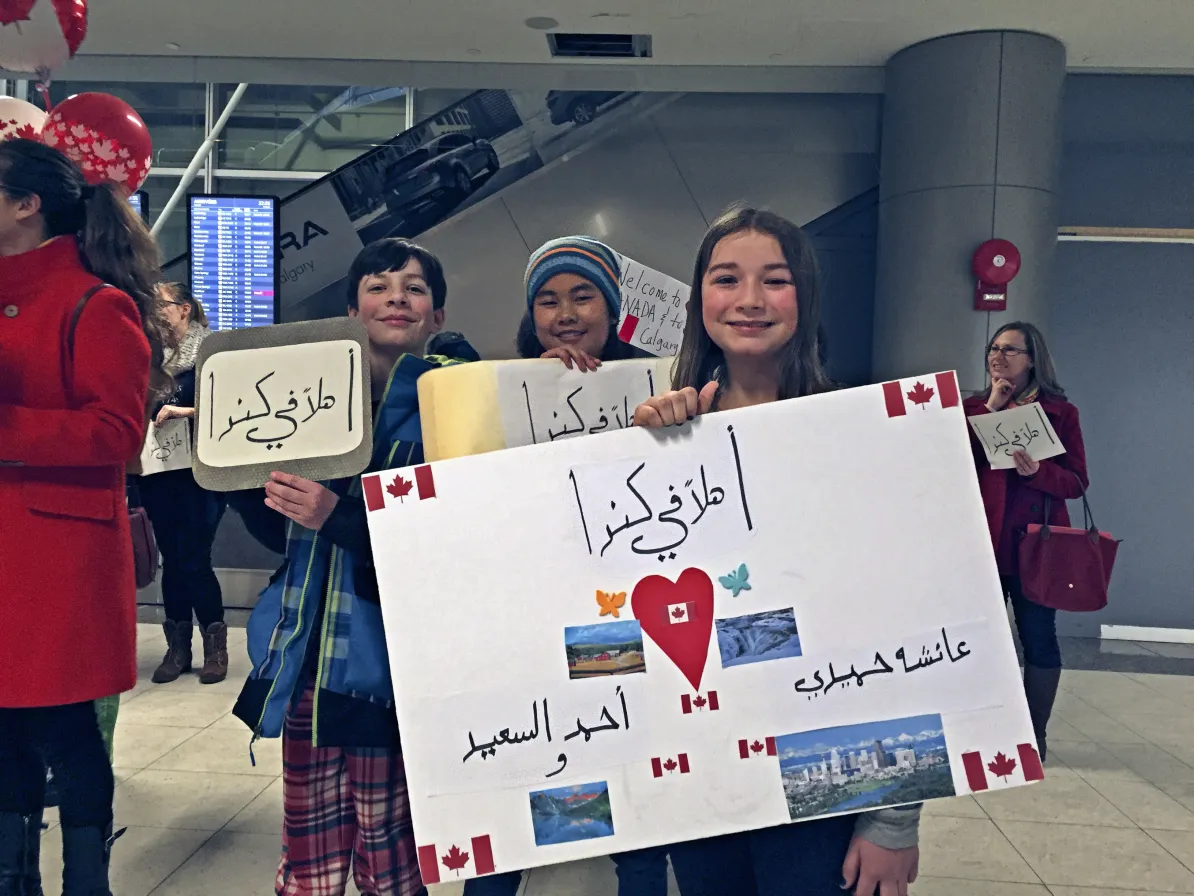 children holding sign at airport