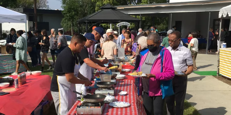 People lining up to get omelets for breakfast.