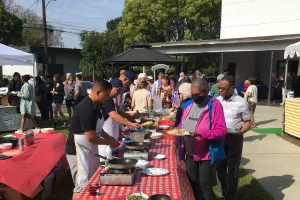 People lining up to get omelets for breakfast.