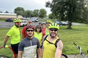 group of bicycle riders smile at camera