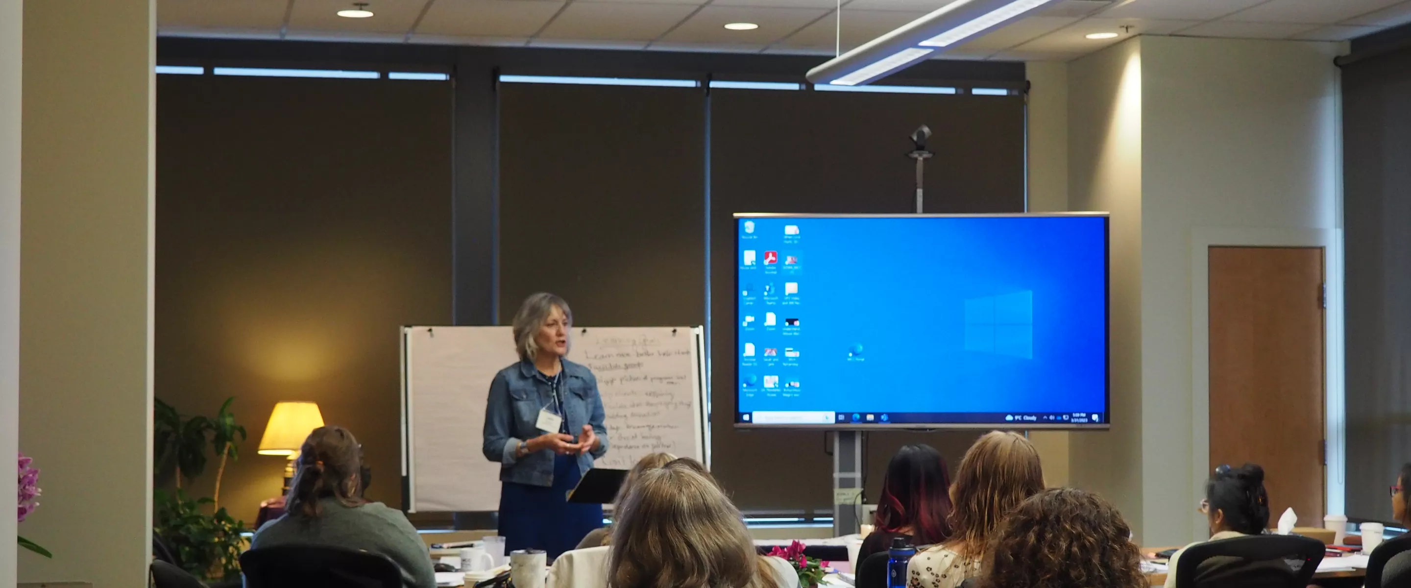 A woman standing in front of a room of seated students.