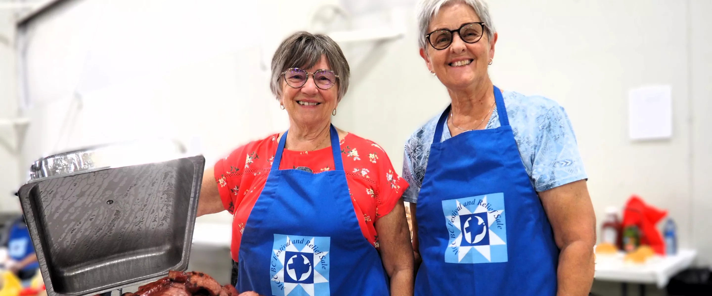 Two Festival volunteers at the MCC Festival for World Relief. With a chafing dish of Mennonite sausage