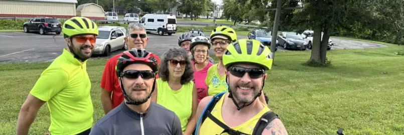 group of bicycle riders smile at camera