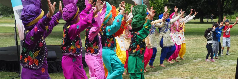 A line of people dancing in a park