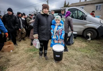 Woman and child holding disaster relief suppliesthis is the block