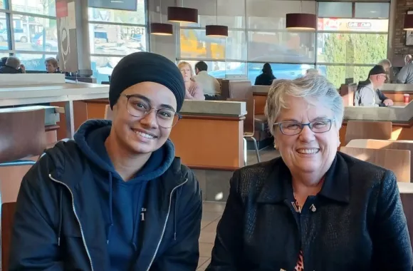 Two people sitting together smiling for a photo