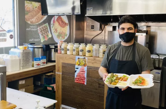 A man presenting food prepared in a restaurant