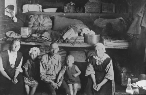 An old black and white photo of people sitting in a room