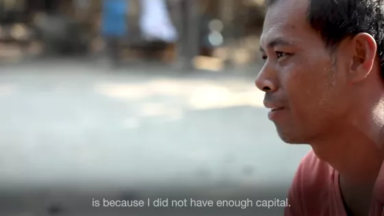 A Cambodian man in a pink shirt being interviewed