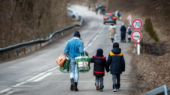 A woman and two children walk down a road.