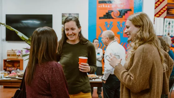 A group of three people chatting together in the Global Center