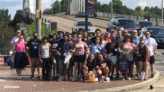 Group standing in front of Edmund Pettis Bridge in Selma, Alabama.