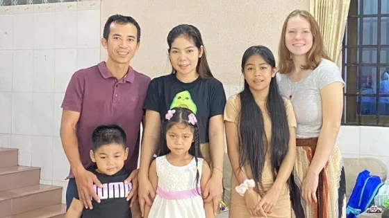 A man and two women stand with three children