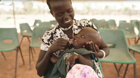 Mother holding her infant and smiling