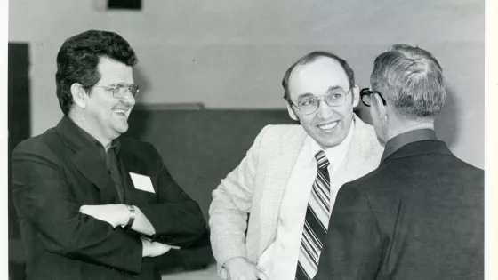 Three men are engaged in a conversation