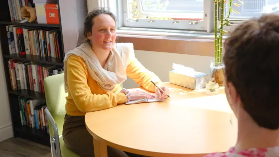 Two women sit at a table in conversation