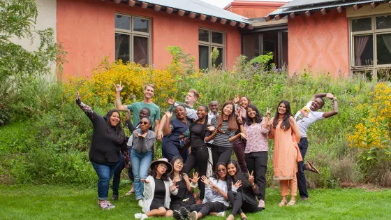 A group of 17 young adults strike various poses together.