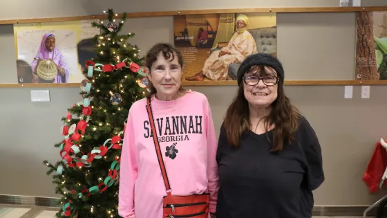 Two women standing in front of Christmas tree